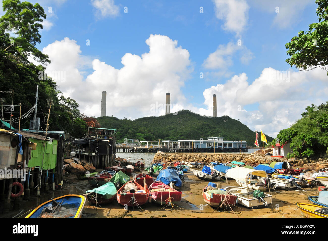 Stilt dwellings of Lamma fisherfolk, looking towards the stacks of Lamma Power Station, Yung Shue Wan, Lamma Island, Hong Kong Stock Photo