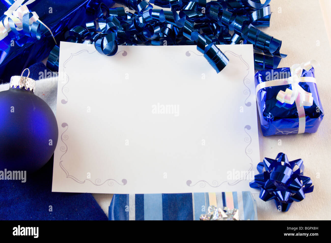 blank Christmas card with blue bauble, presents, bow, ribbon and copyspace Stock Photo