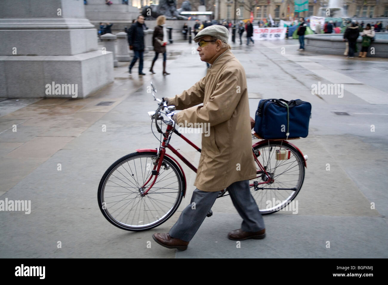 Man pushing his bicycle Trafalgar square, London, England, Britain, UK Stock Photo