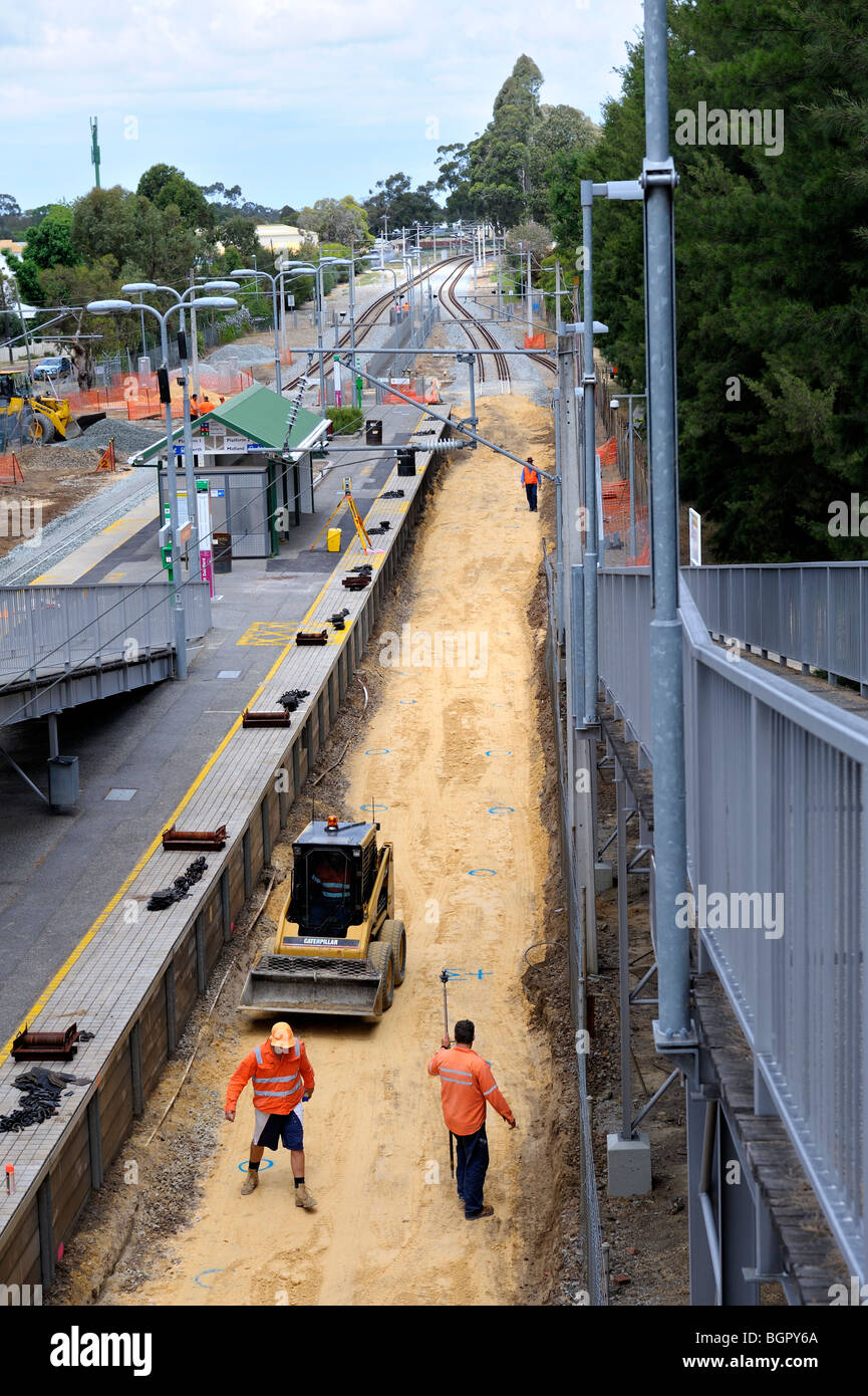 Workmen preparing foundation for new sleepers on suburban railway line. Guildford, Perth, Western Australia Stock Photo