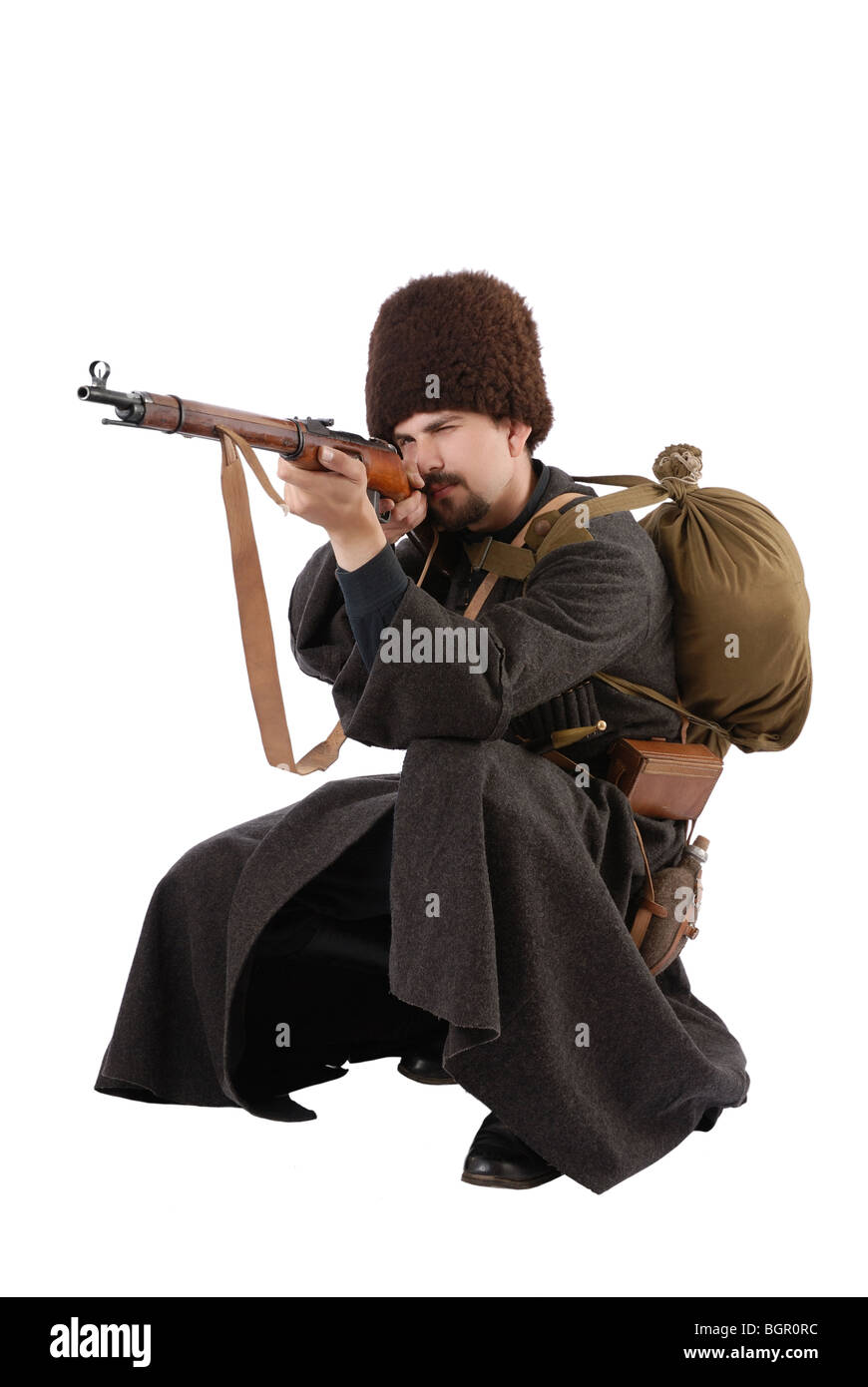 Russian Cossack points a rifle in squatting position. The living history. Stock Photo