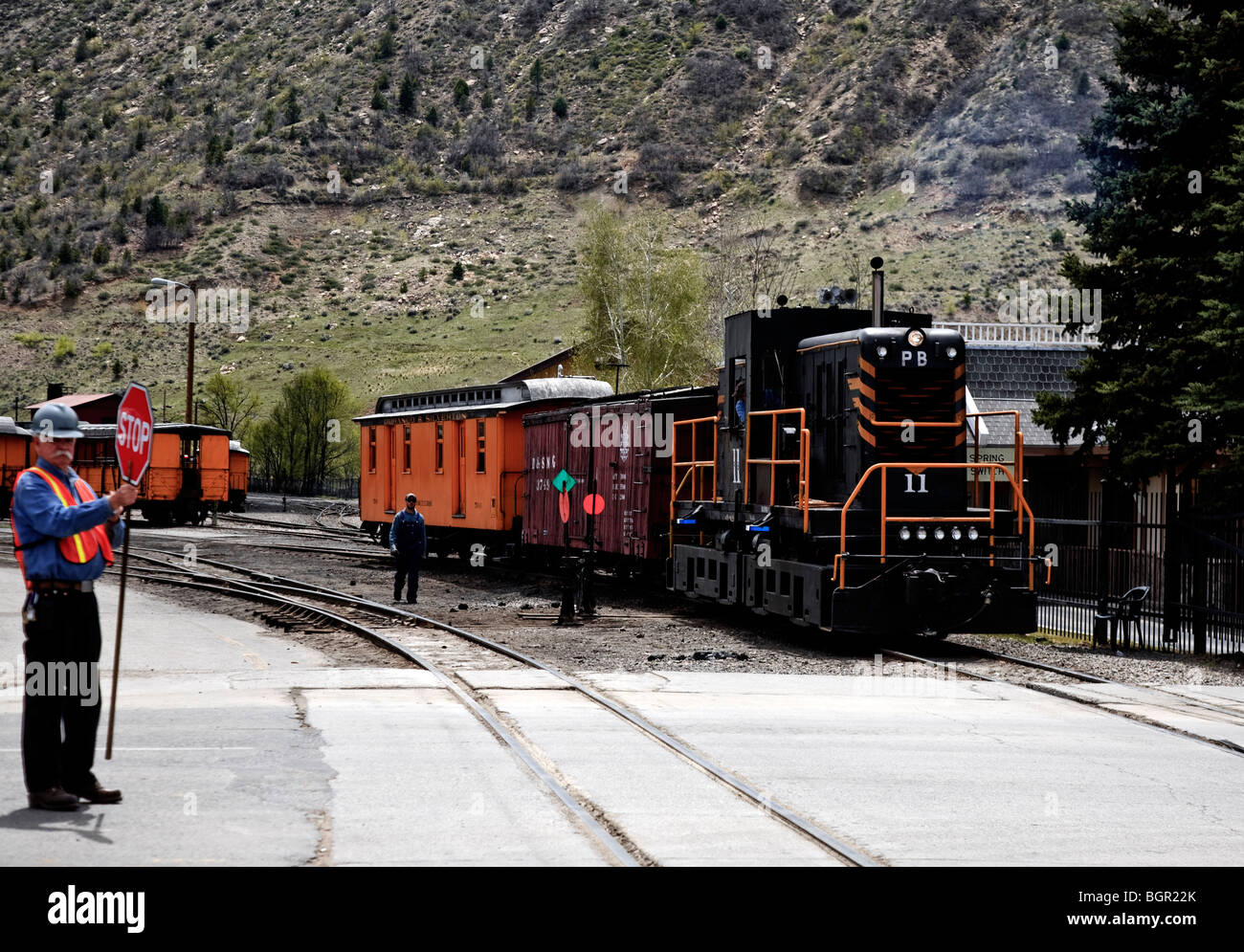 Crew stopping traffic while the historic narrow gauge railroad Durango-Silverton train crosses East College Drive, Durango, USA Stock Photo