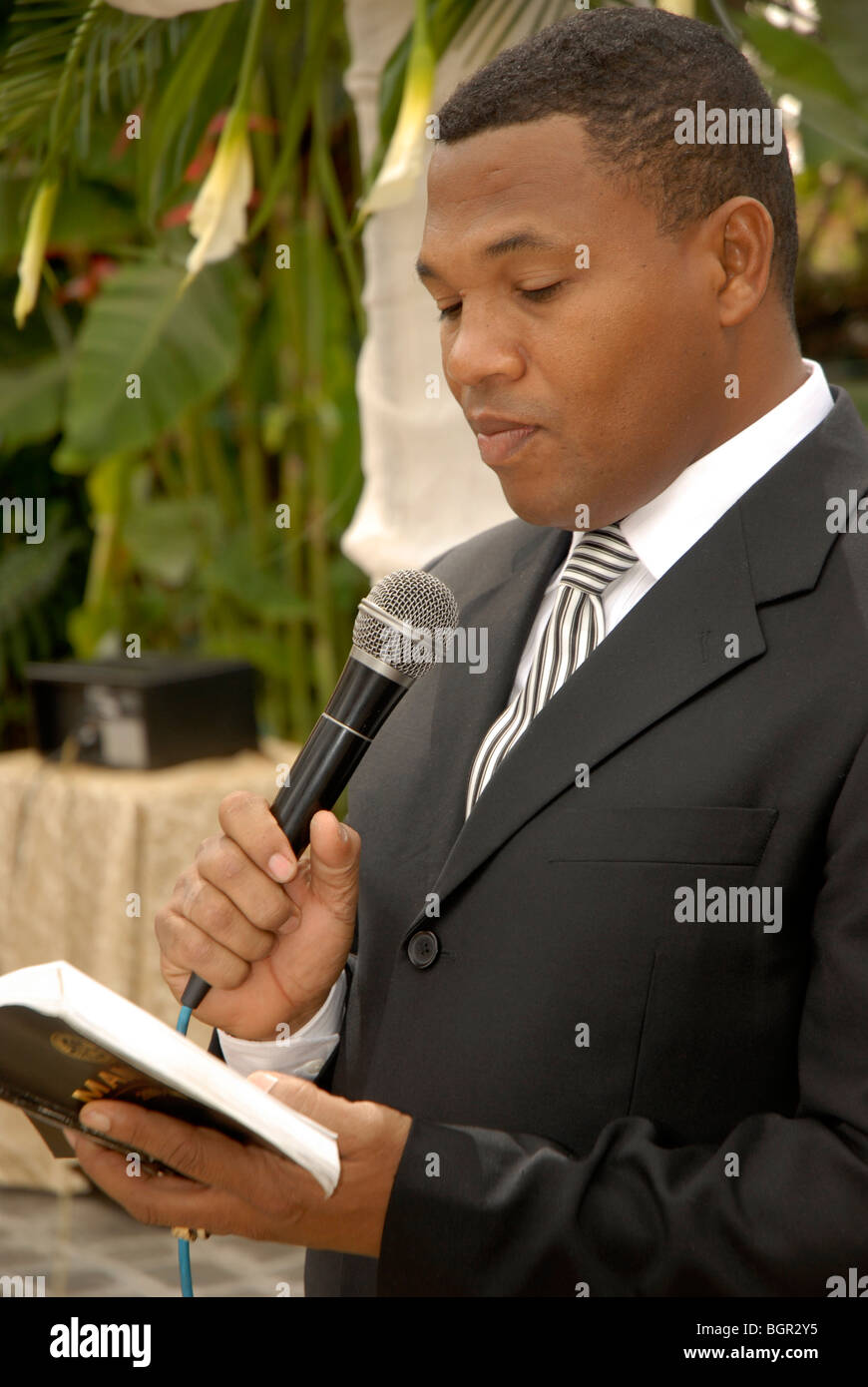 LECTURE BIBLIA TRAJE SERVICIO PALABRAS MINISTER THEOLOGICAL SPIRITUAL HOLY CHURCH MESSAGE SECT RITE LECTURA IGLESIA ESPIRITUAL MENSAJE MICROFONO LIBRO Stock Photo