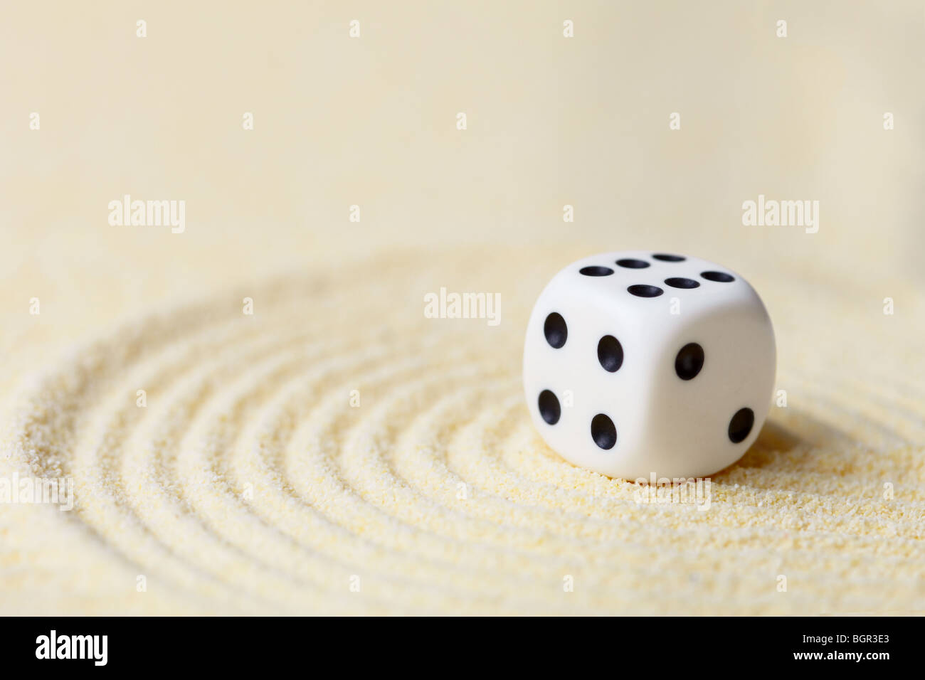 Art composition from playing dice on a sand surface Stock Photo