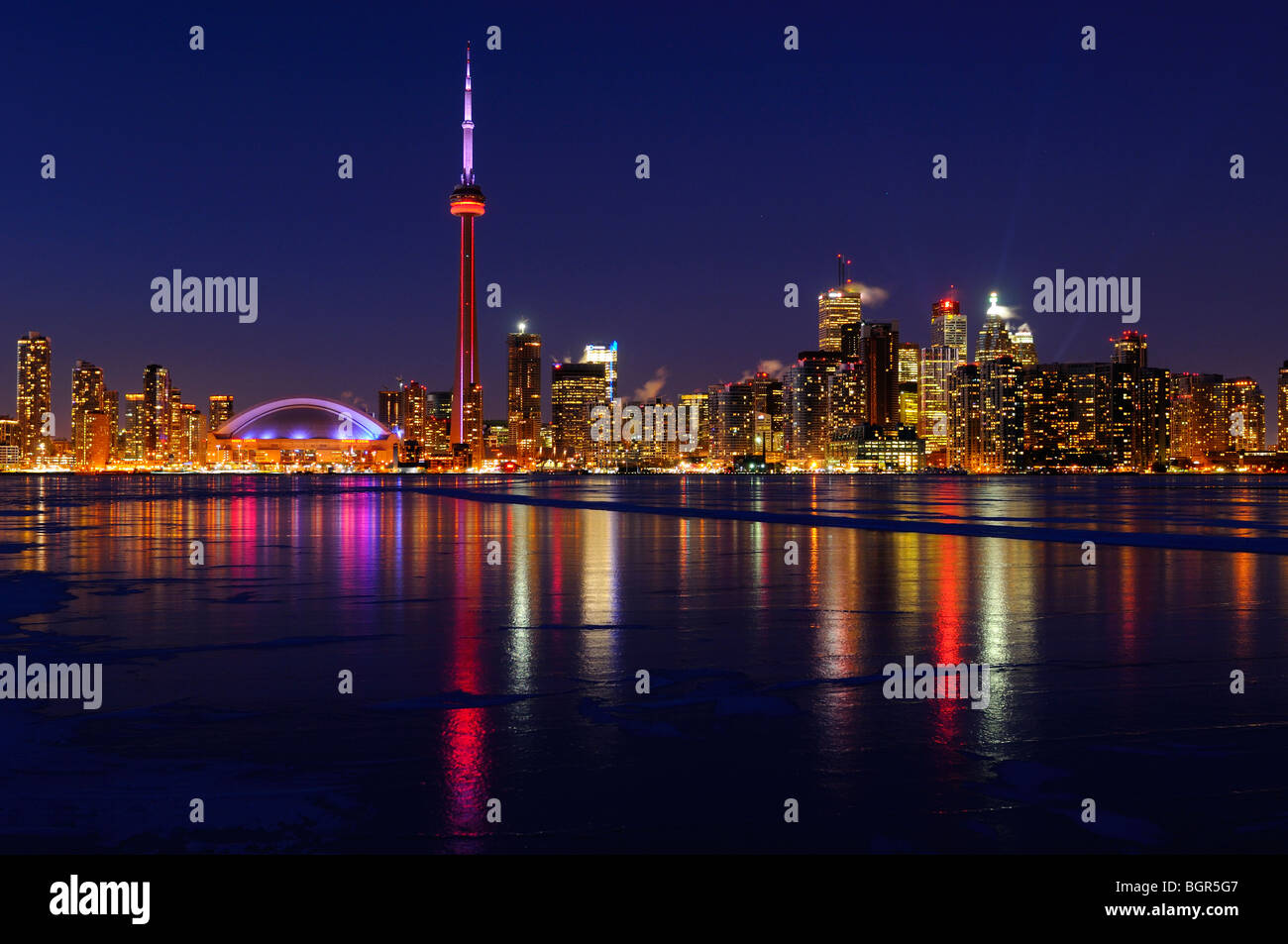 Toronto city skyline lights at night reflected on the frozen ice covered Lake Ontario in winter Stock Photo