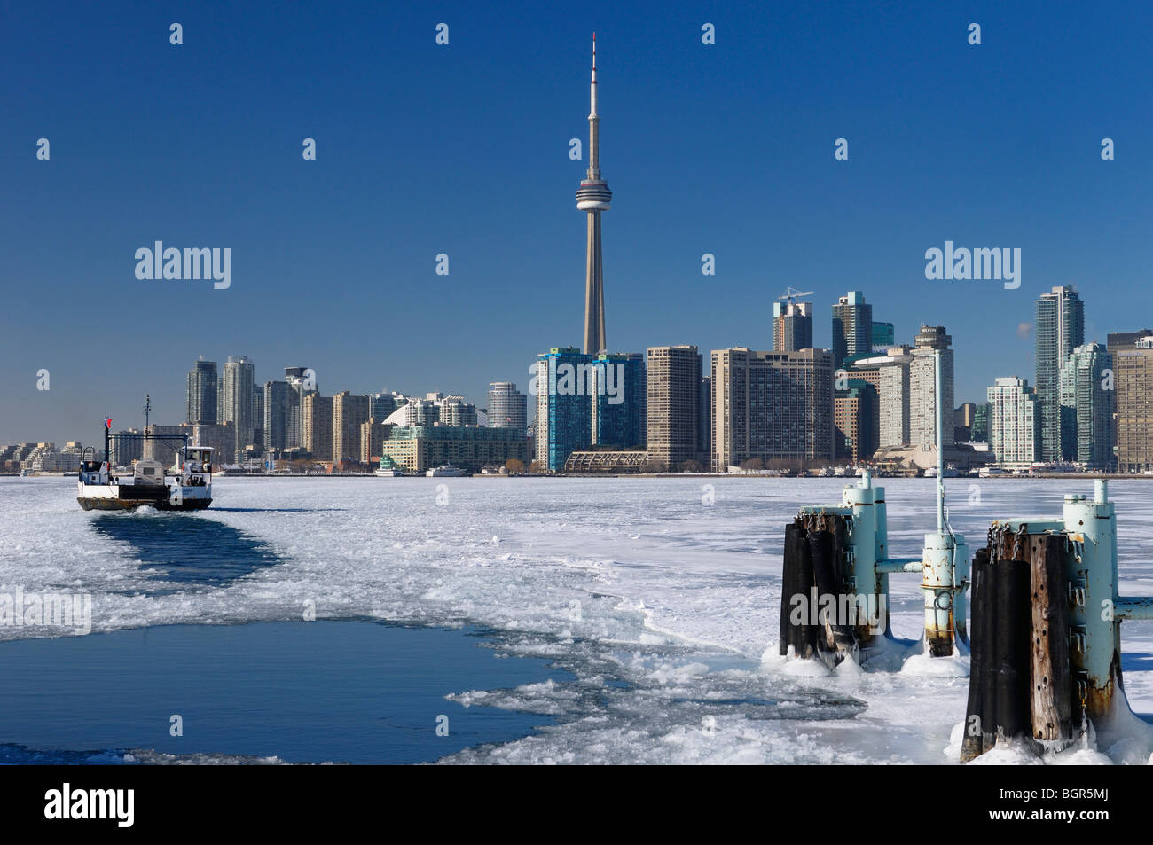 Wards Island Ferry returning to Toronto in winter keeping a channel open on an ice covered Lake Ontario Stock Photo
