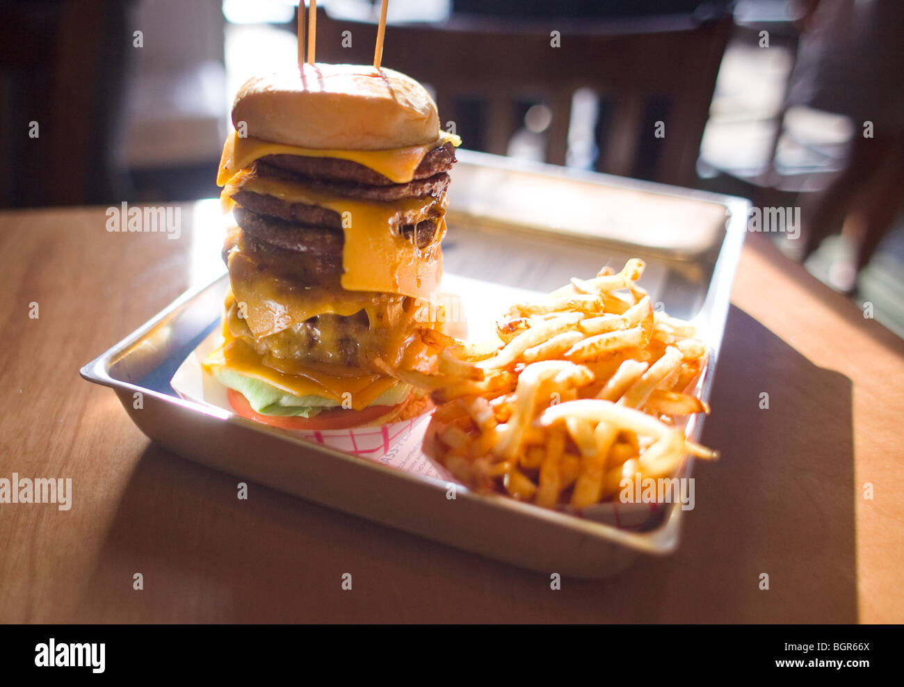A 10 patty hamburger with a side of fries Stock Photo