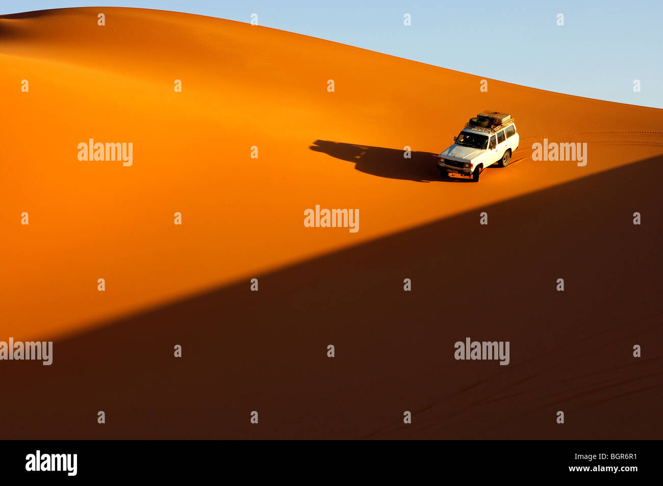 four-wheel-drive-car-driving-at-sunset-on-the-pristine-slope-of-a-sand