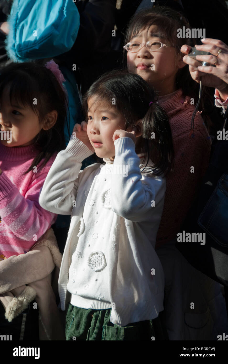 Paris, France, Chinese Children Holding Ears from Loud Noise, From Firecrackers in 'Chinese new year' Carnival in Street Stock Photo