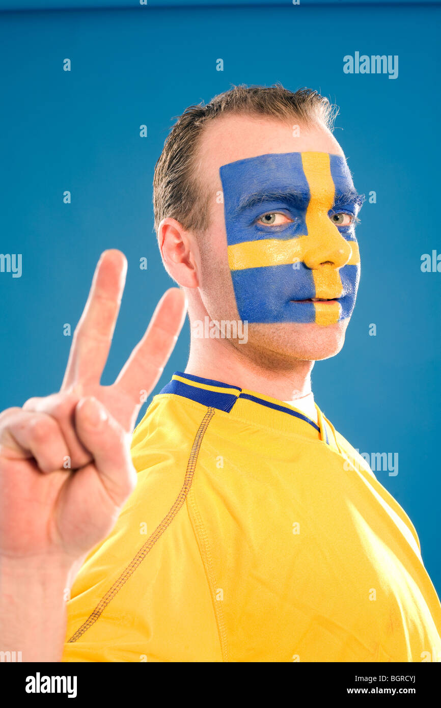 A man with the Swedish flag painted in his face. Stock Photo