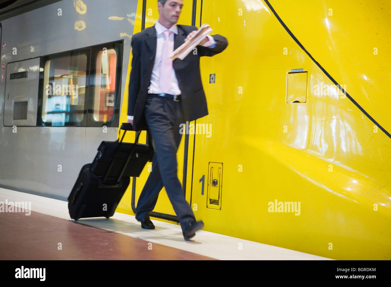 Businessman walking on a platform next to a train, Stockholm, Sweden. Stock Photo
