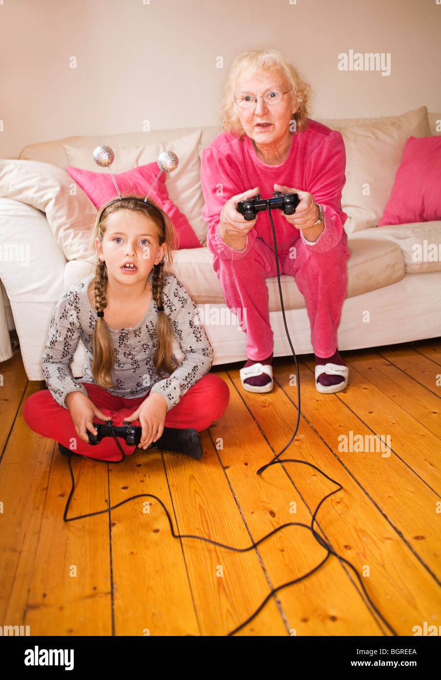 An elderly woman playing video game with her granddaughter, Sweden. Stock Photo