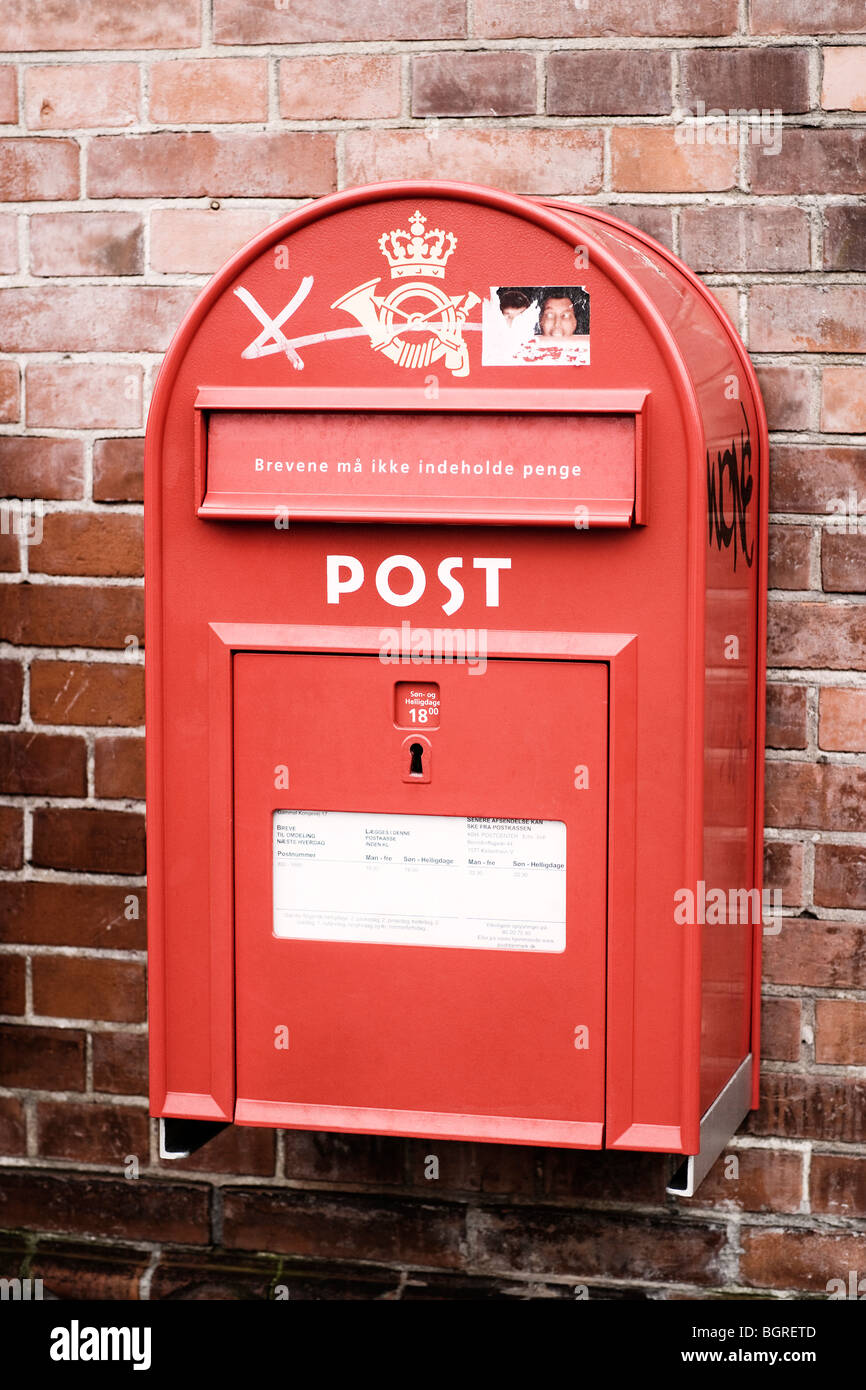 A red postbox on a bricked wall, Denmark. Stock Photo