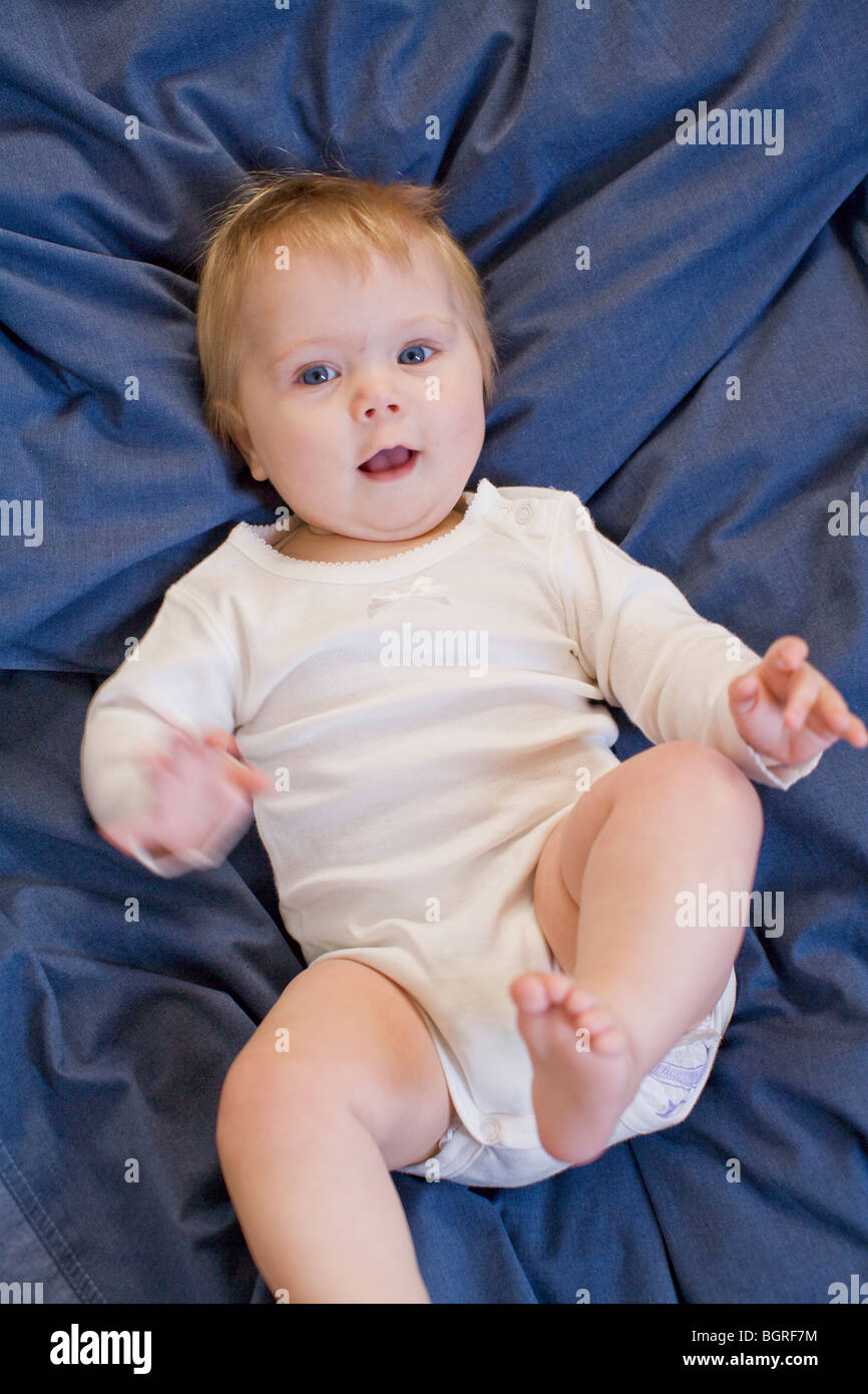 A baby lying awake in bed, Sweden Stock Photo Alamy