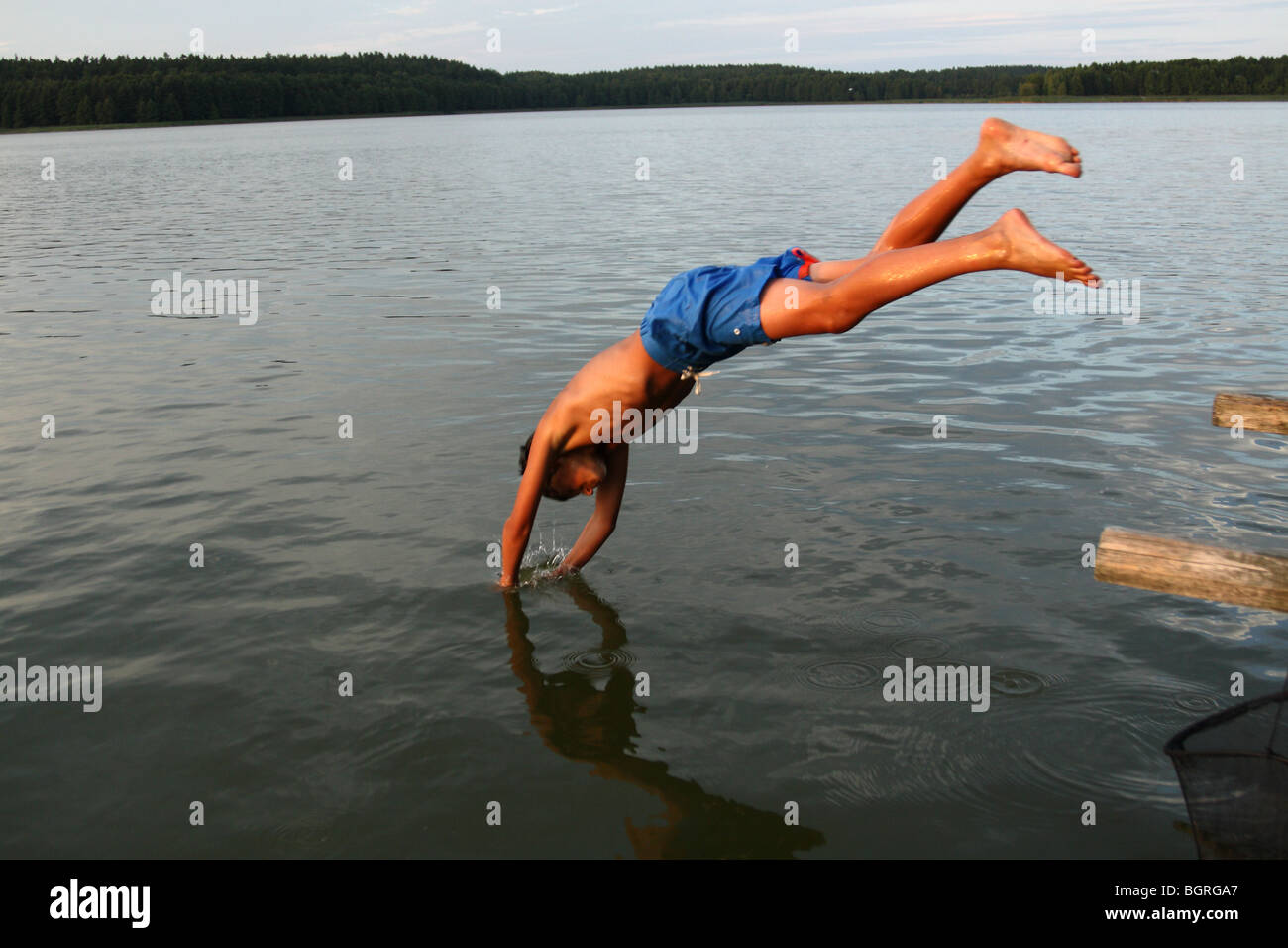 Young boy jumping into a lake Stock Photo - Alamy
