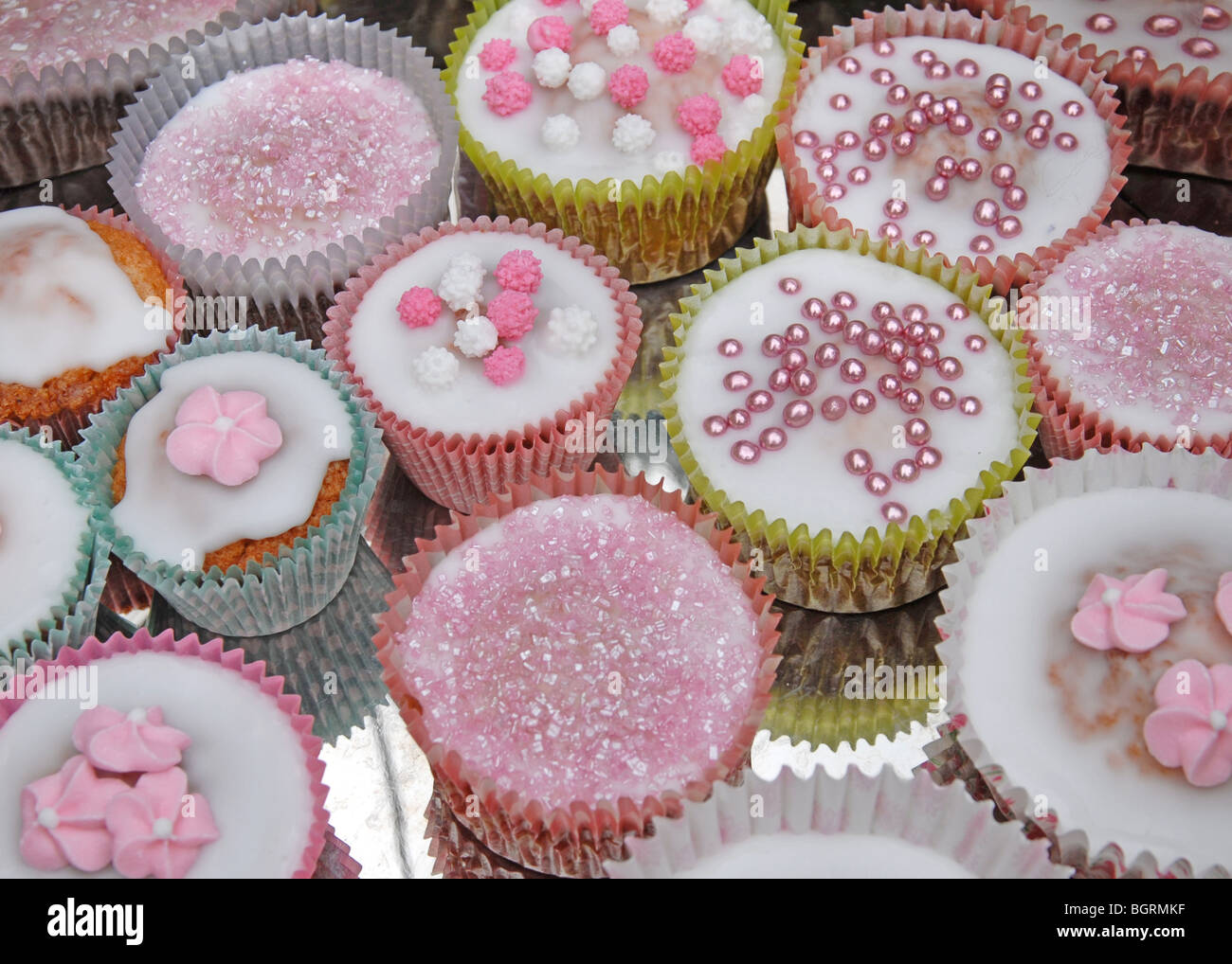A selection of decorated cup cakes on a silver background Stock Photo