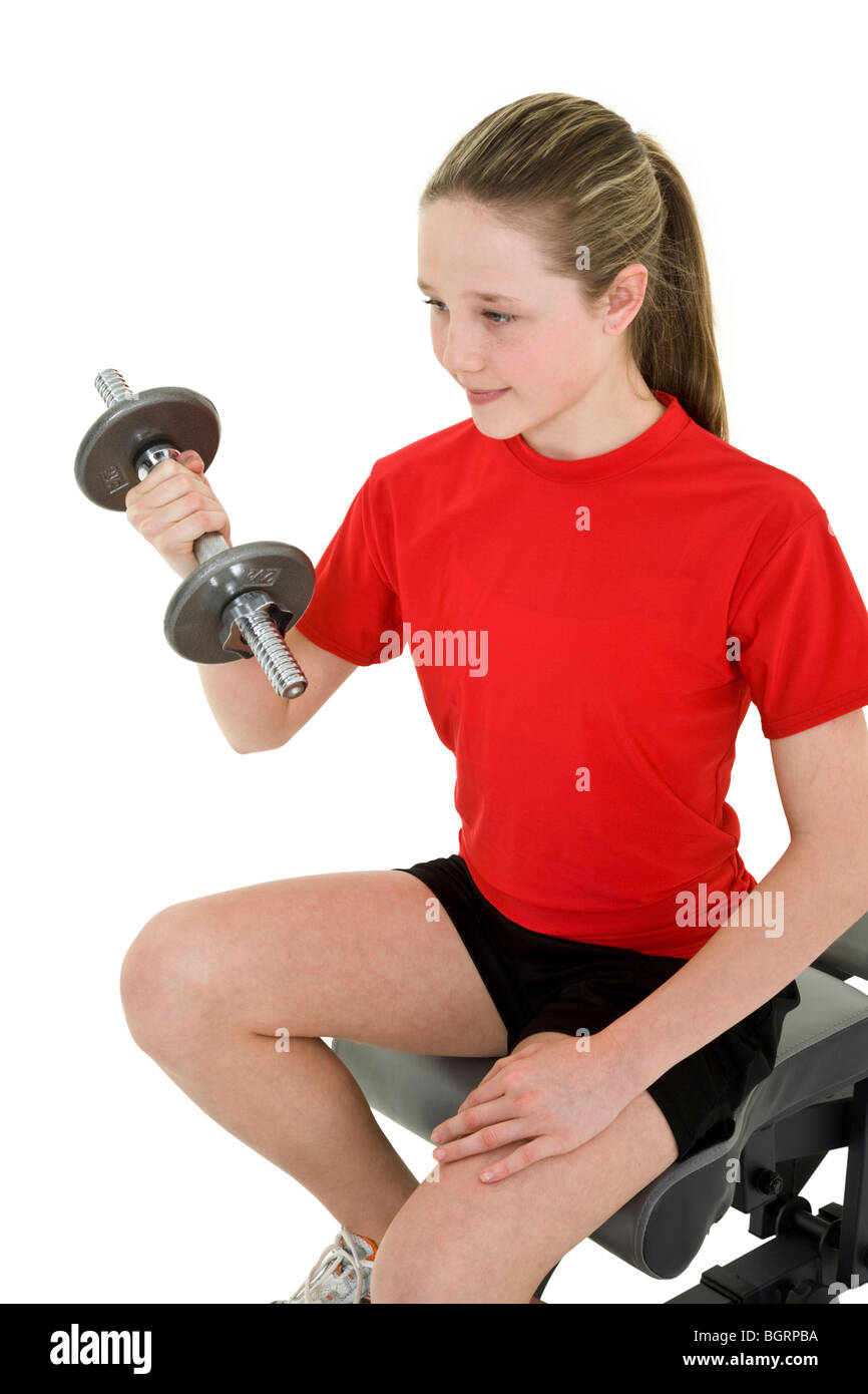 Caucasian preteen female lifting weights using a dumbbell on a white background Stock Photo