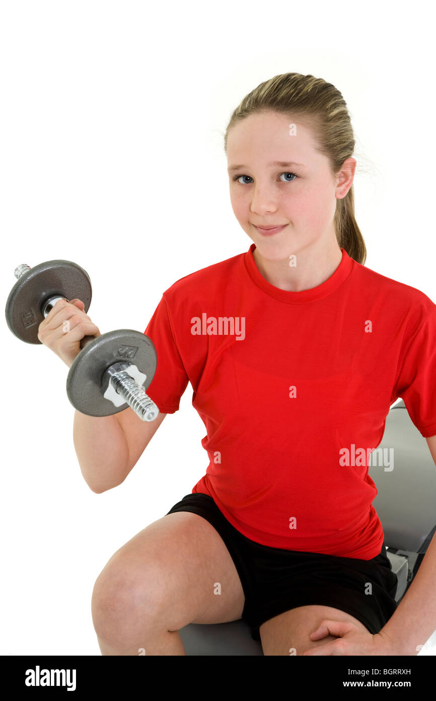 Caucasian preteen female lifting weights using a dumbbell on a white background Stock Photo