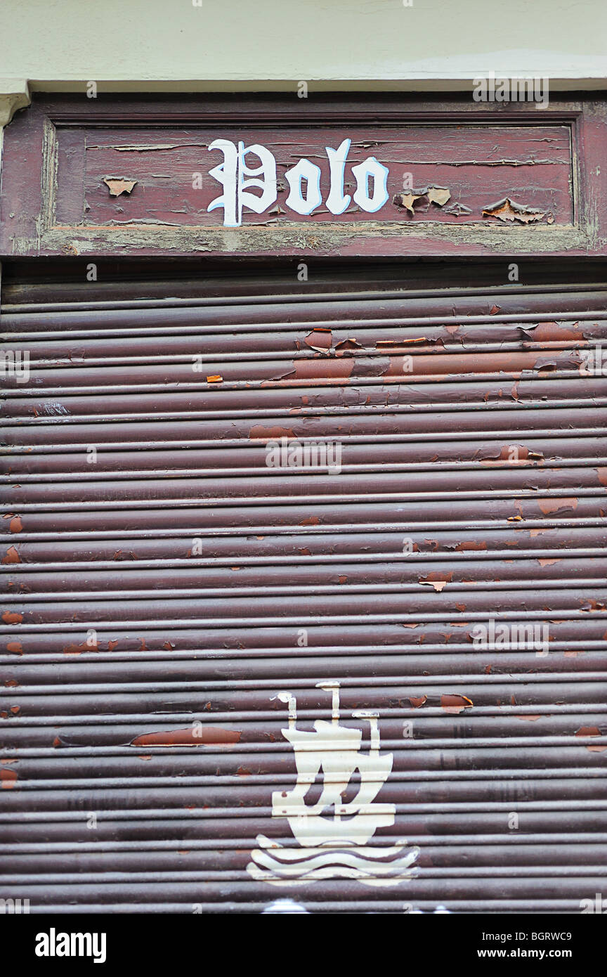 brown shutters closed a trade, with the word pole at the top and the drawing of a ship on the bottom Stock Photo