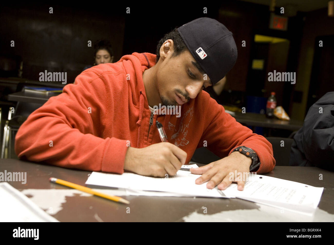 Teen works in a GED class, general equivalency  diploma at a community center in New York City toward his high school diploma Stock Photo