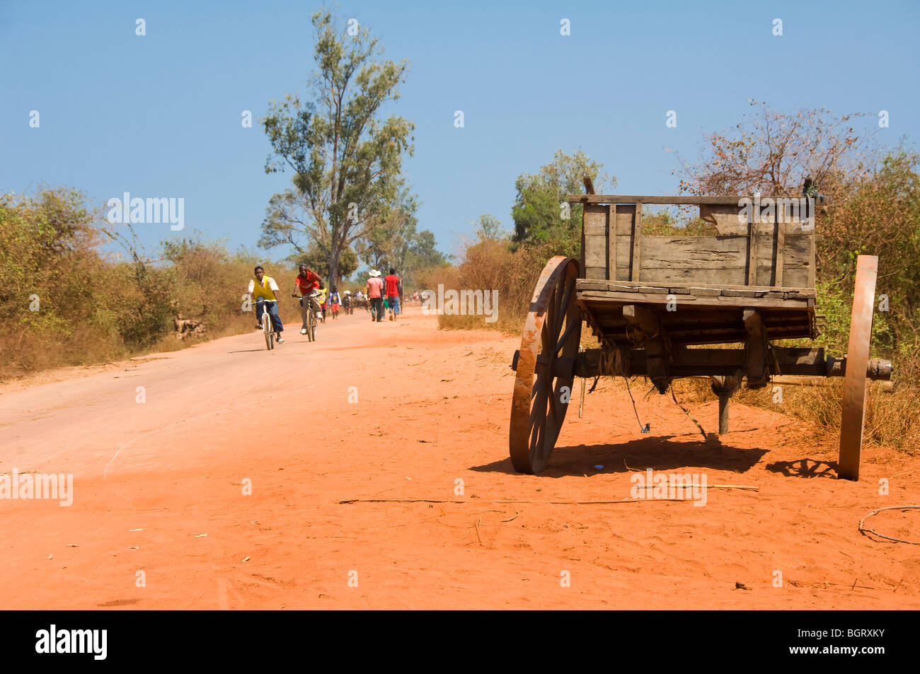 Malagasy people on a red road, Morondava, Madagascar Stock Photo