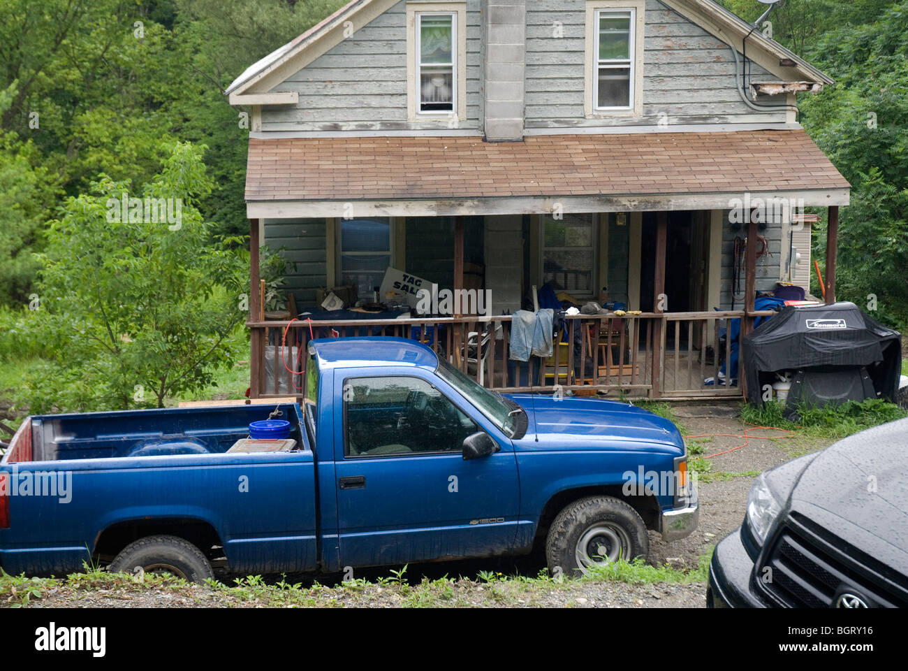 Rural American house with porch and tag sale & pick-up truck Stock Photo