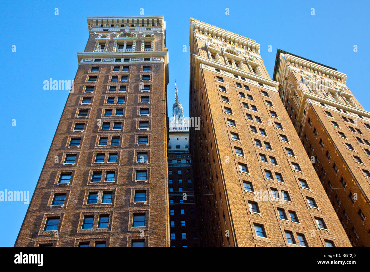 Tip of Empire State Building behind a large apartment building in Midtown Manhattan, New York City Stock Photo