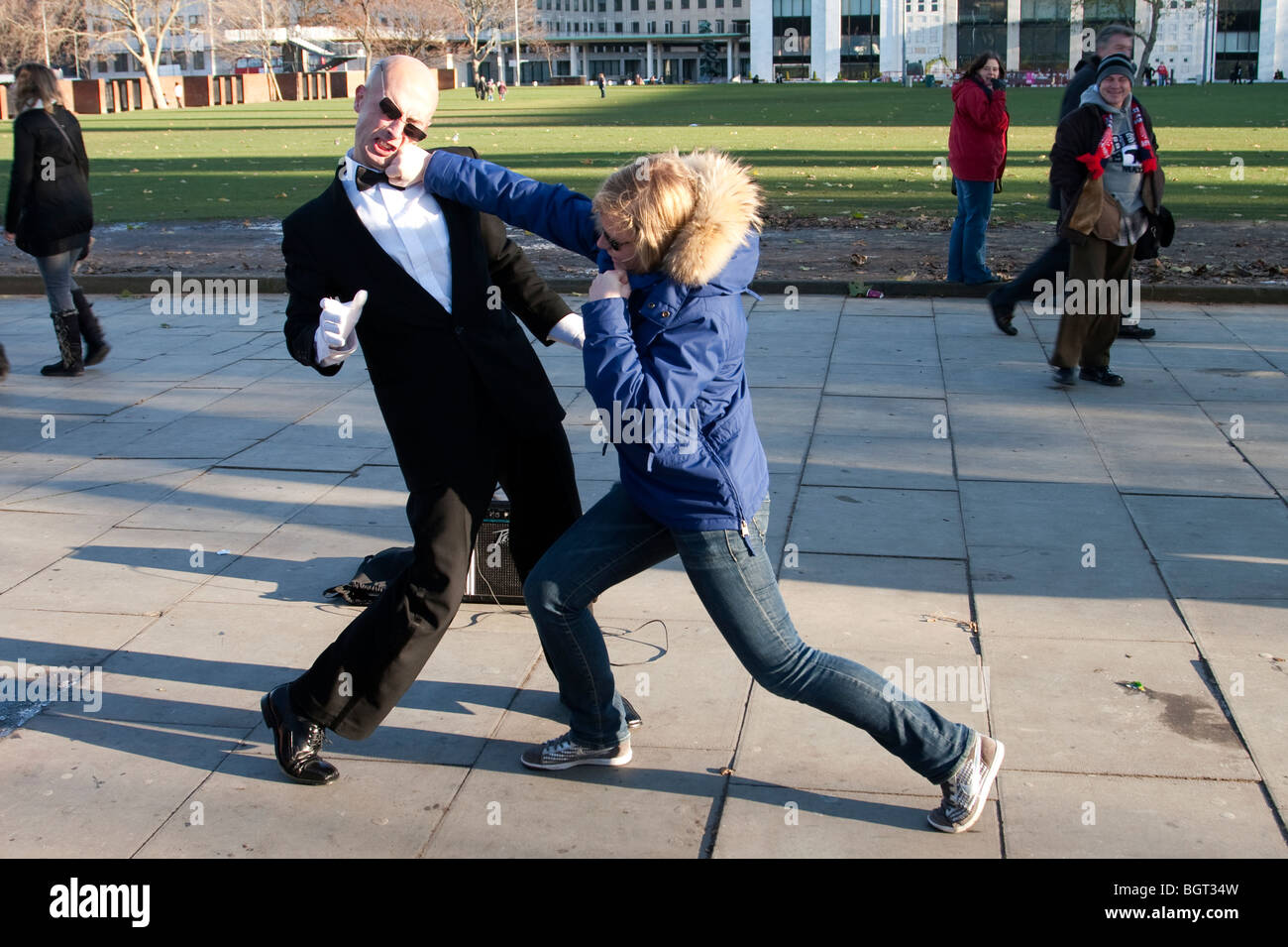 Busker on the Southbank of the Thames being punched by a member of the public, London Stock Photo