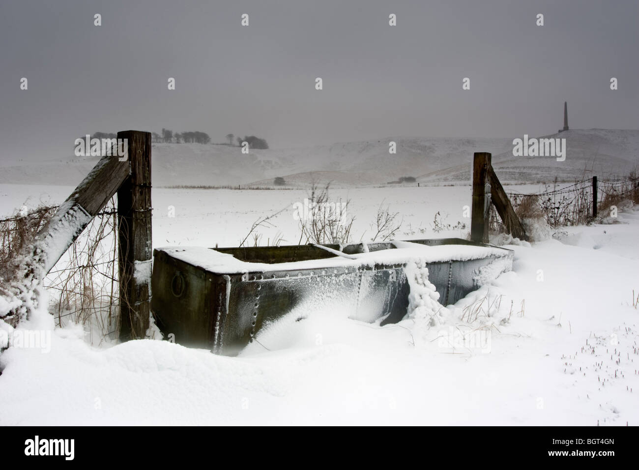 A snow bound animal water trough in the shadow of the Cherhill White Horse Stock Photo