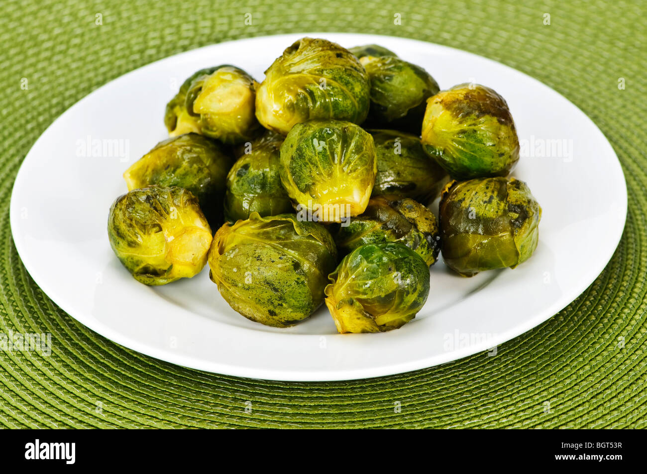 Plate of roasted green brussels sprouts on placemat Stock Photo