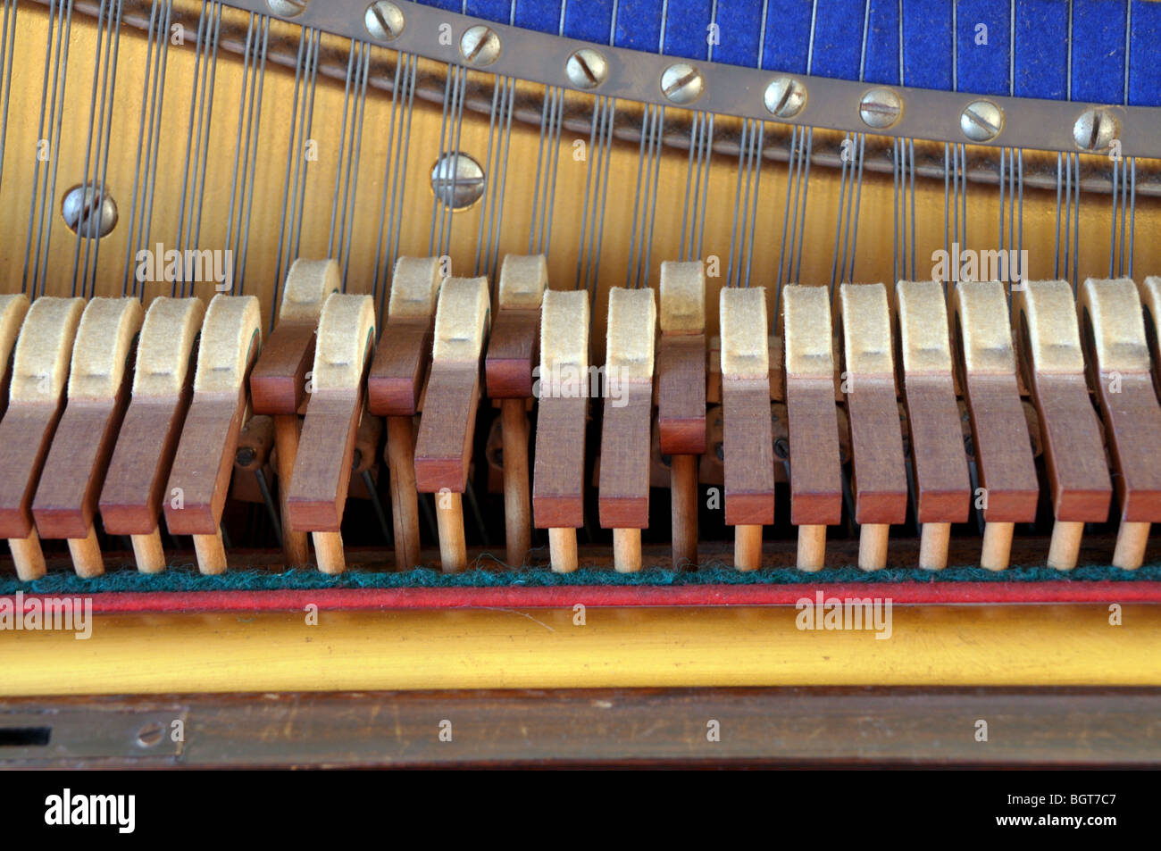 A closeup of piano hammers in use as a pianist strikes a chord on the