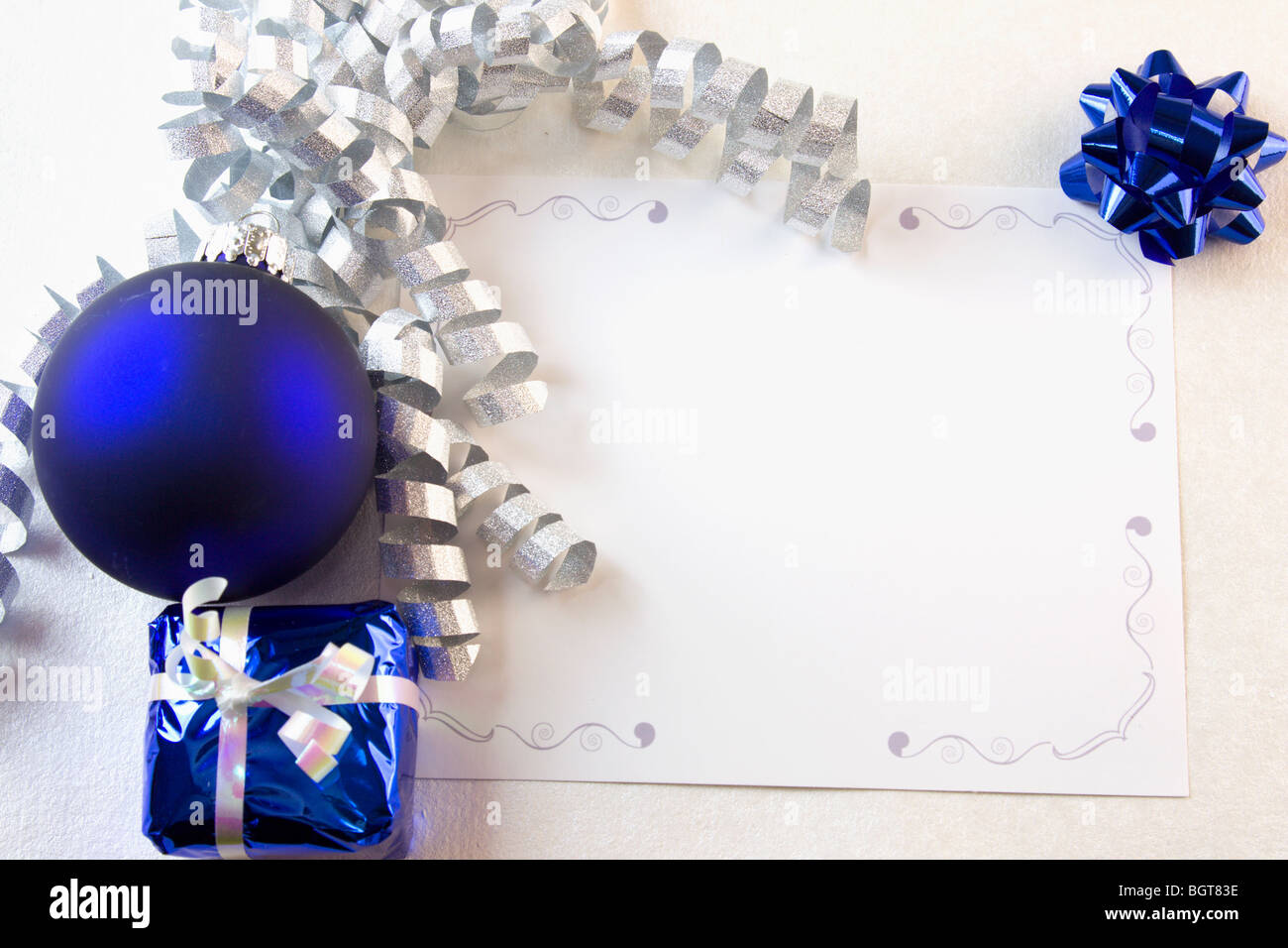 blank Christmas card with blue ornaments and silver curly ribbon with copyspace Stock Photo