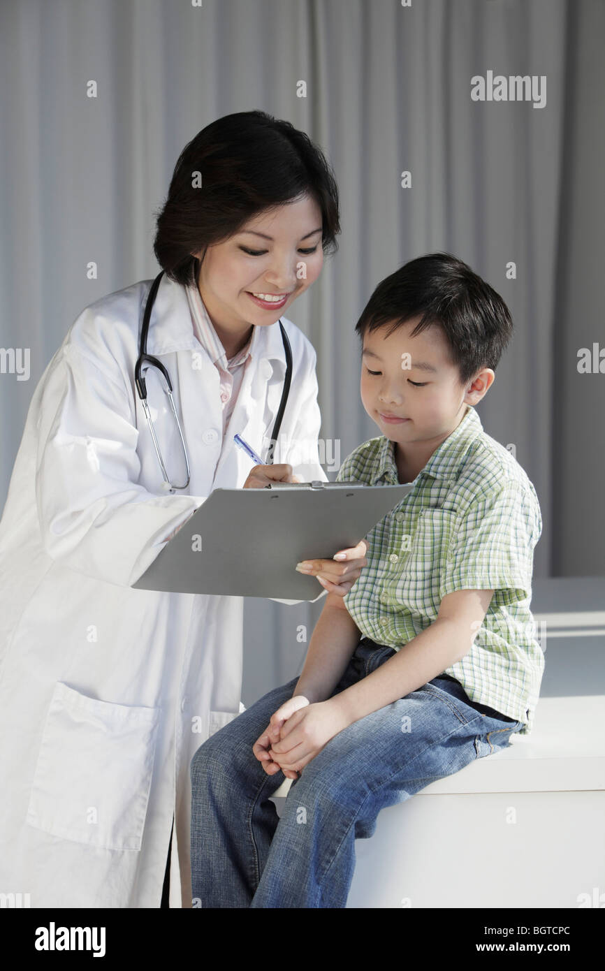 Female doctor giving a young boy a check up Stock Photo