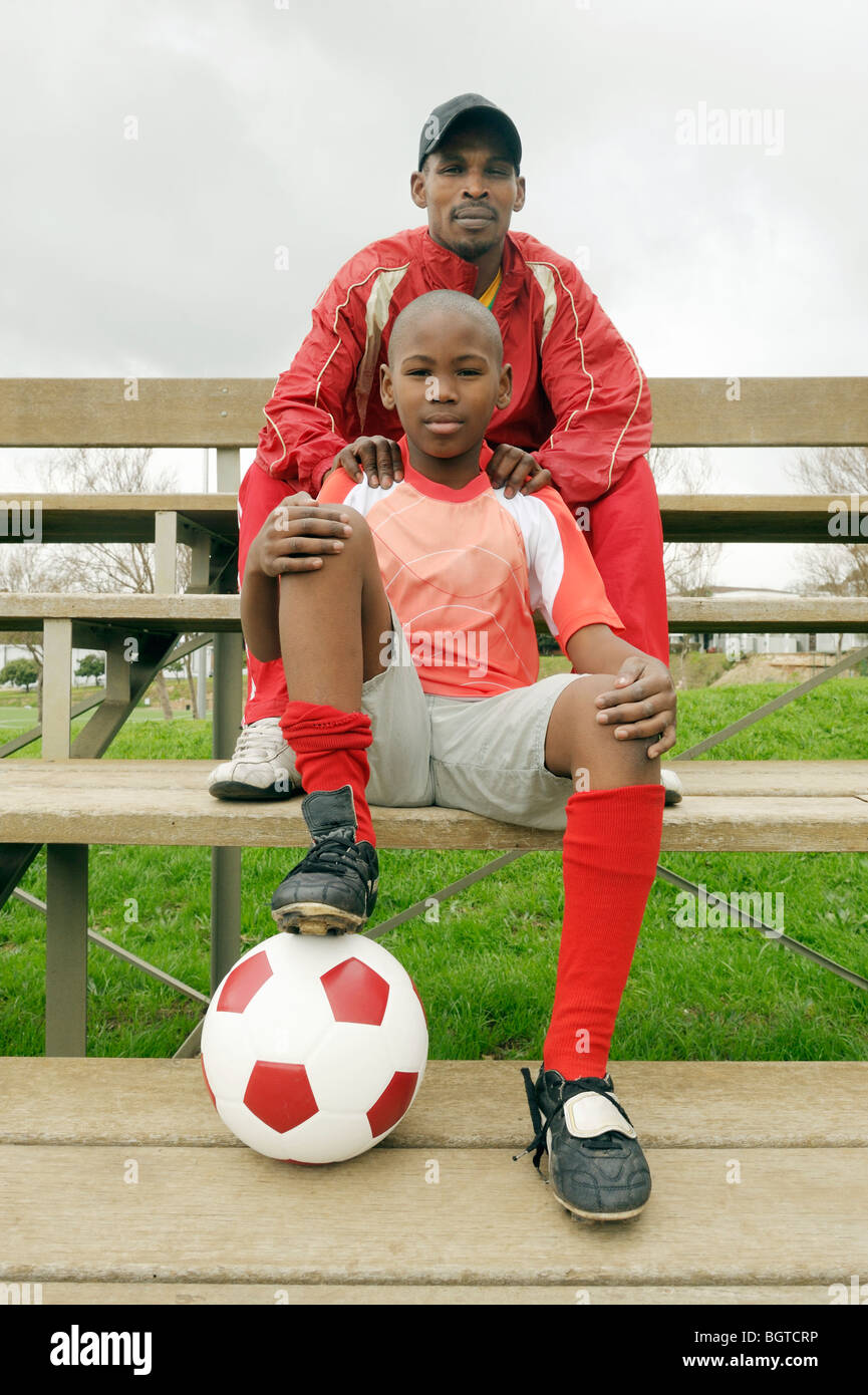 Soccer player with father sitting at side of field, Cape Town, Western Cape , South Africa Stock Photo