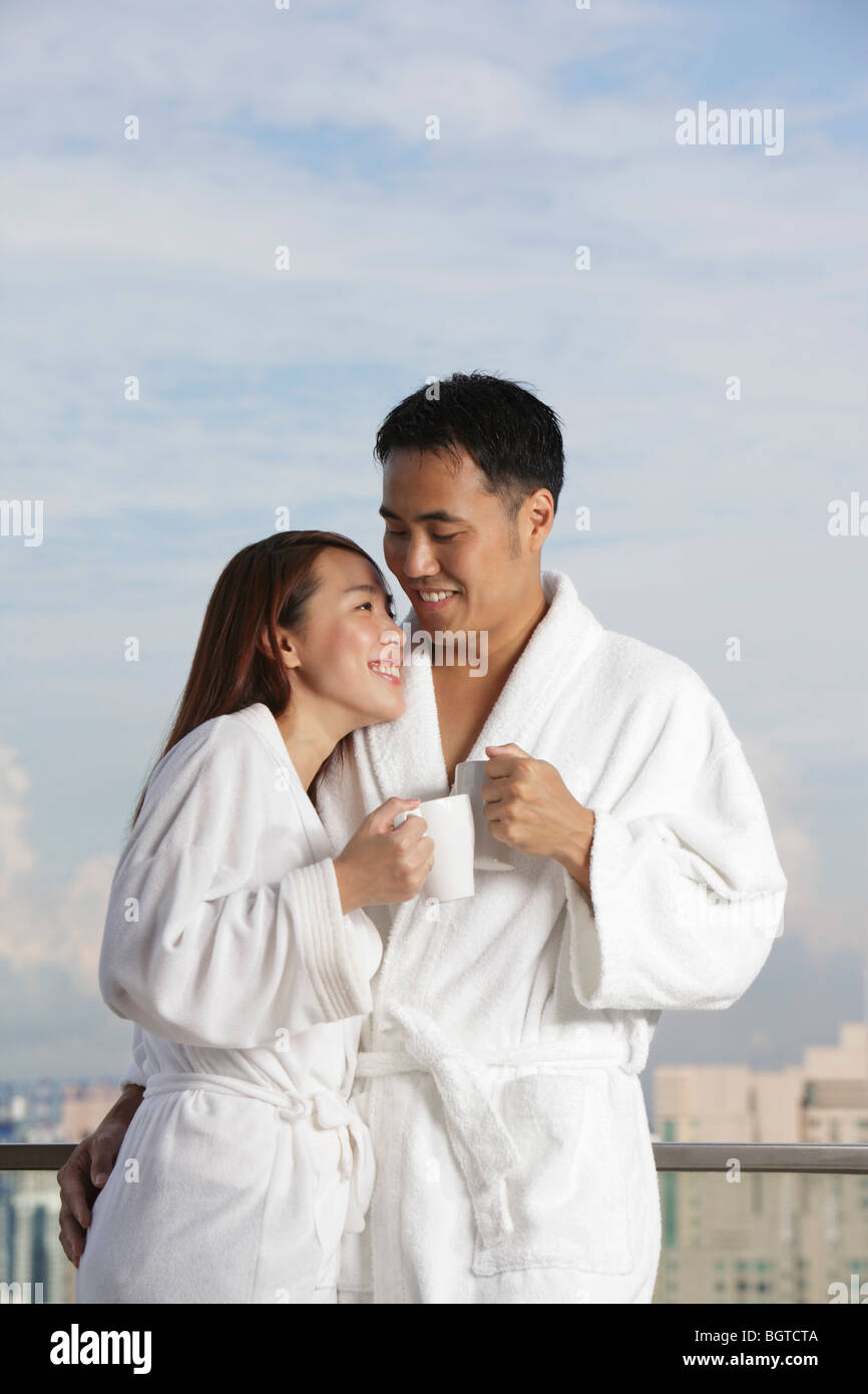 Young couple in robes smiling at each other Stock Photo Alamy