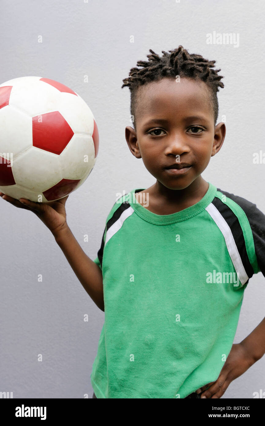 Boy holding up soccer ball, Cape Town, Western Cape , South Africa Stock Photo