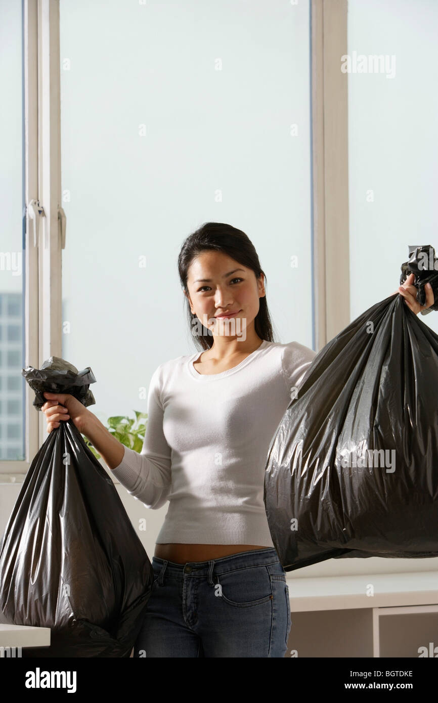 Young woman carrying black trash hires stock photography and images