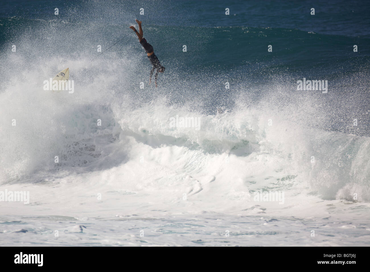 A surfer wipes out on a large wave at Pipleline, Oahu, Hawaii Stock Photo