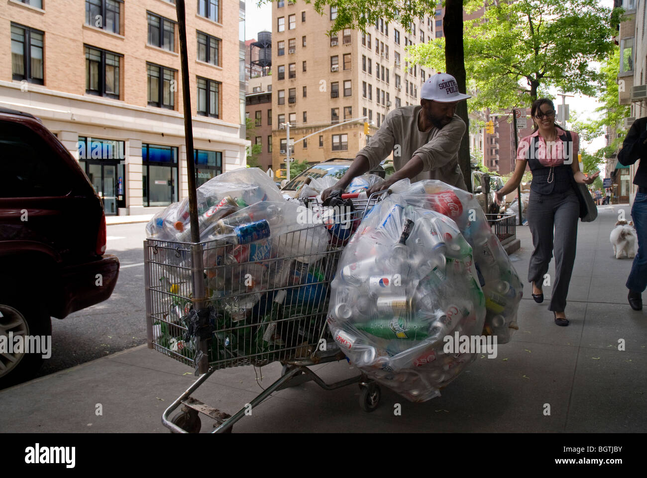Homeless man in NYC collecting cans to take to recycle and get money in