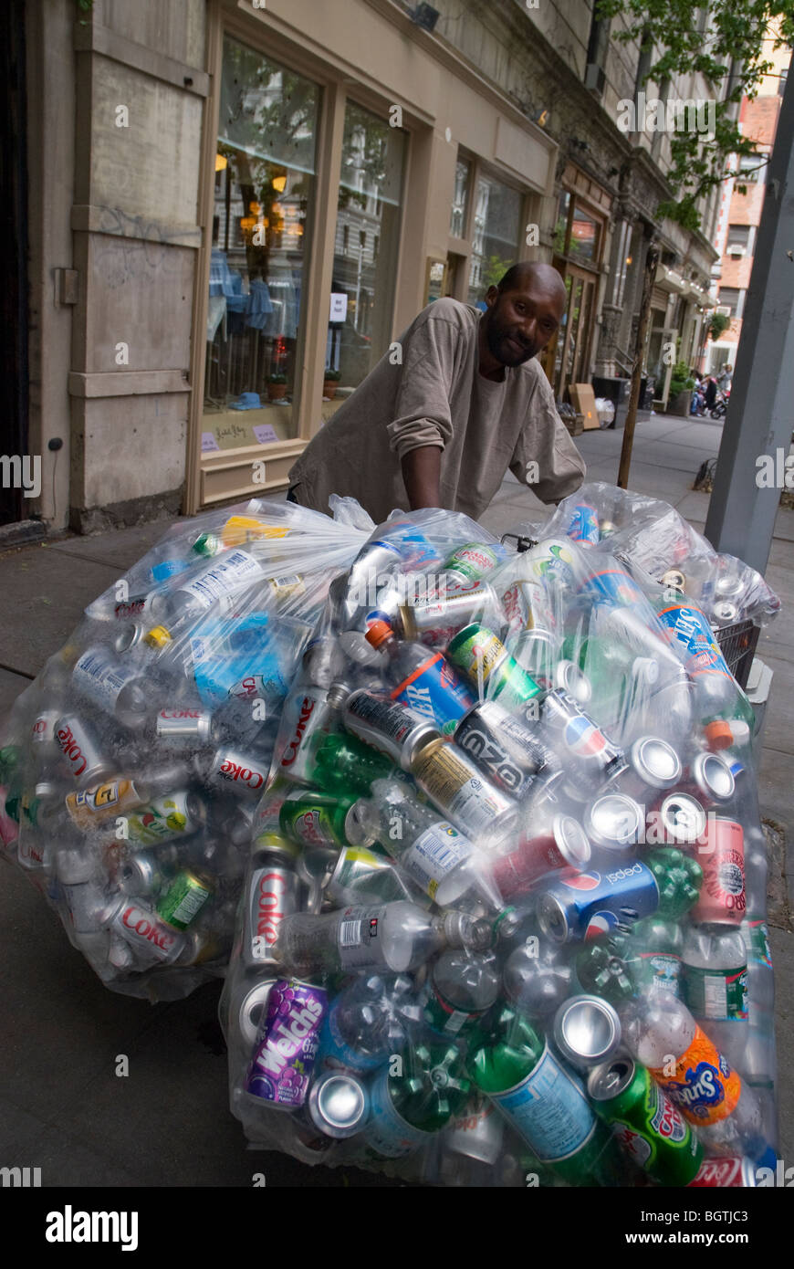 Homeless man in NYC collecting cans to take to recycle and get money in