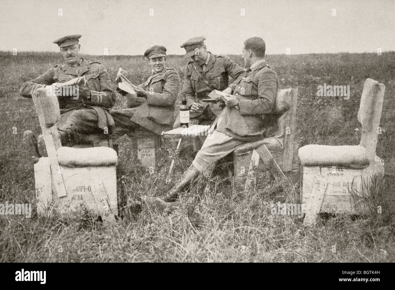 Officers of a British artillery unit relax behind the lines on homemade furniture during the First World War. Stock Photo