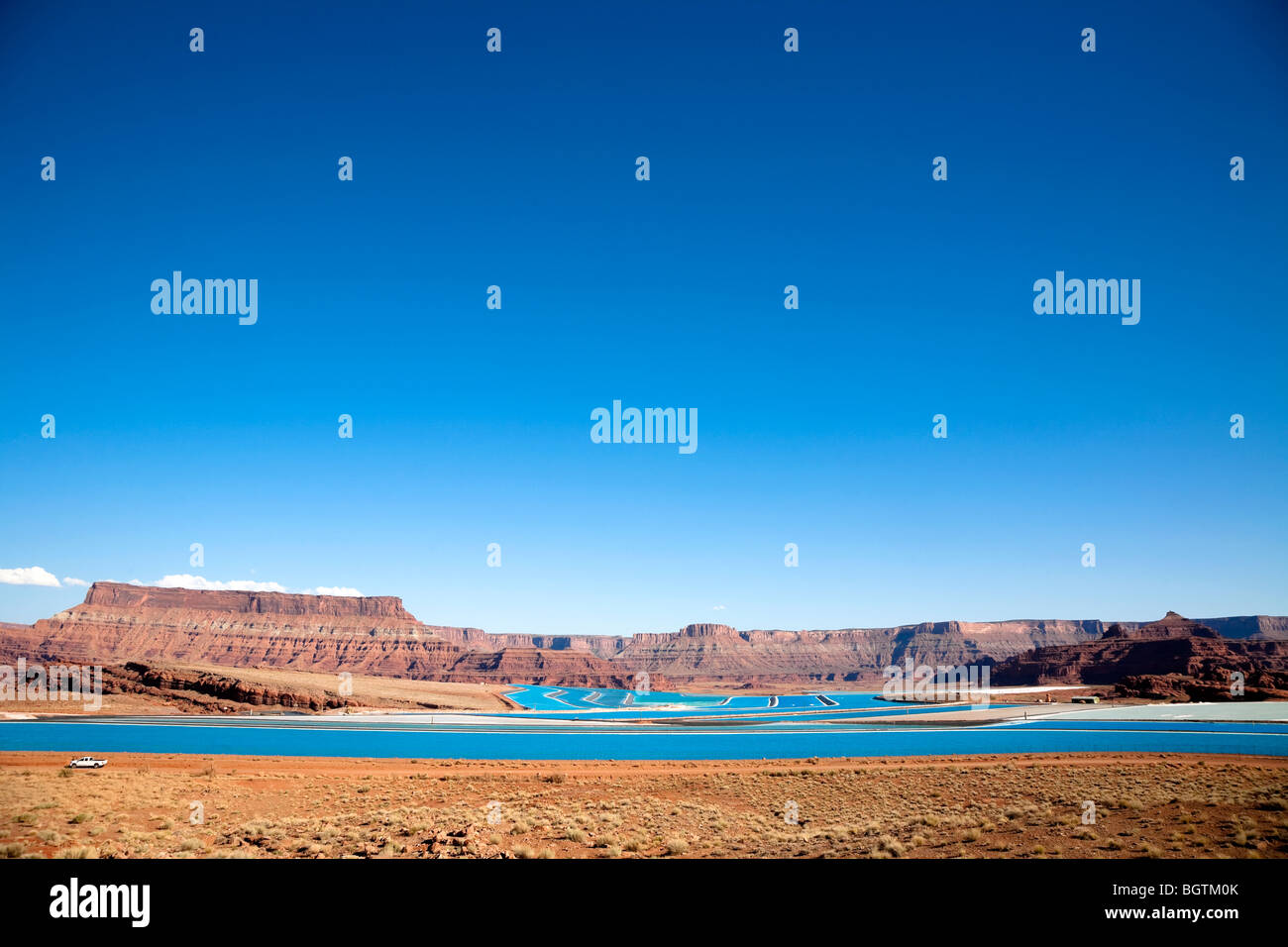 Scene overlooking the bight blue Cane Creek potash mine water evaporation ponds near Moab, Utah, USA Stock Photo