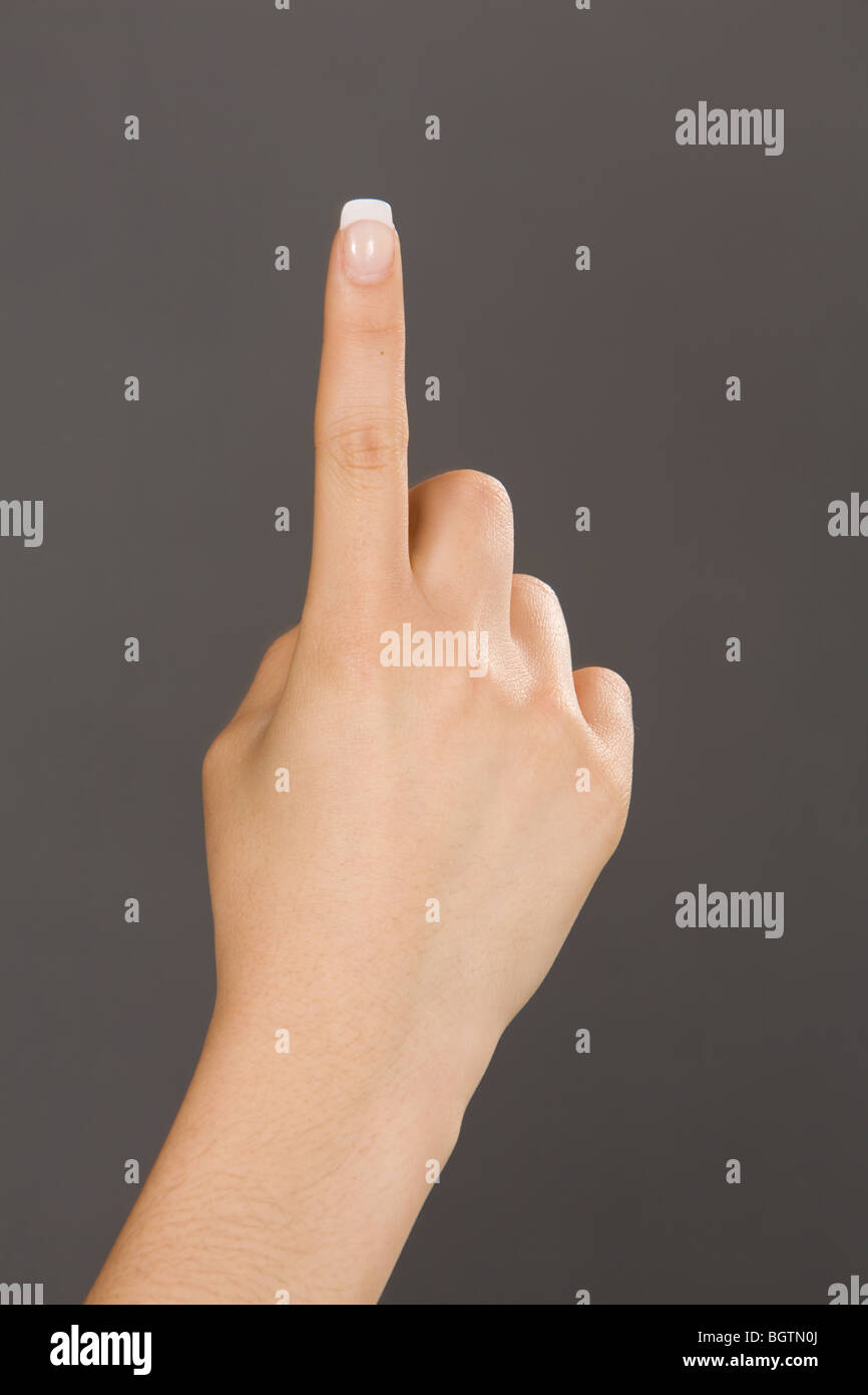 Caucasian female using hand gestures by signing holding up one finger Stock Photo