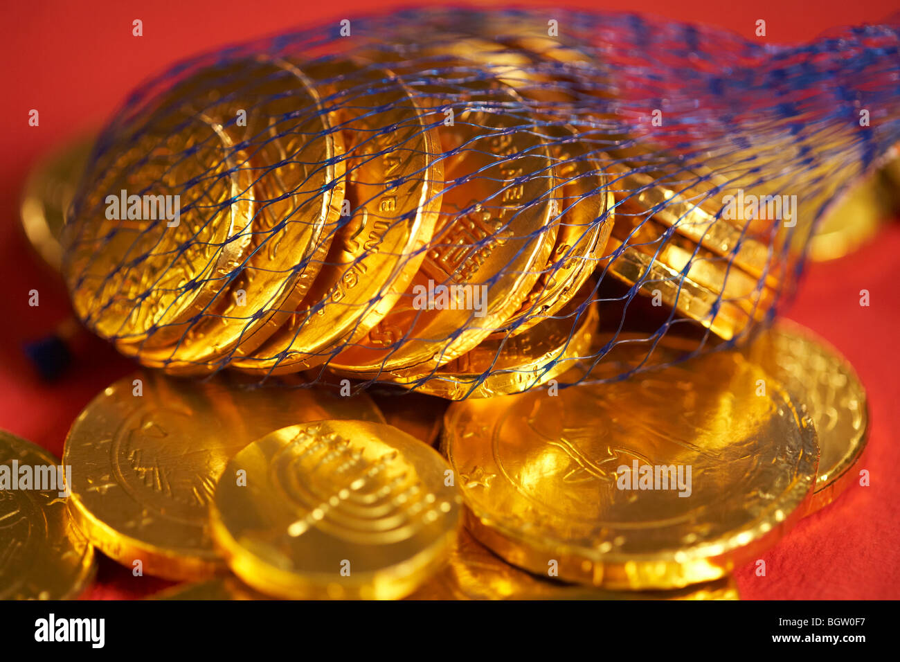Chocolate gold coins on red background Stock Photo - Alamy