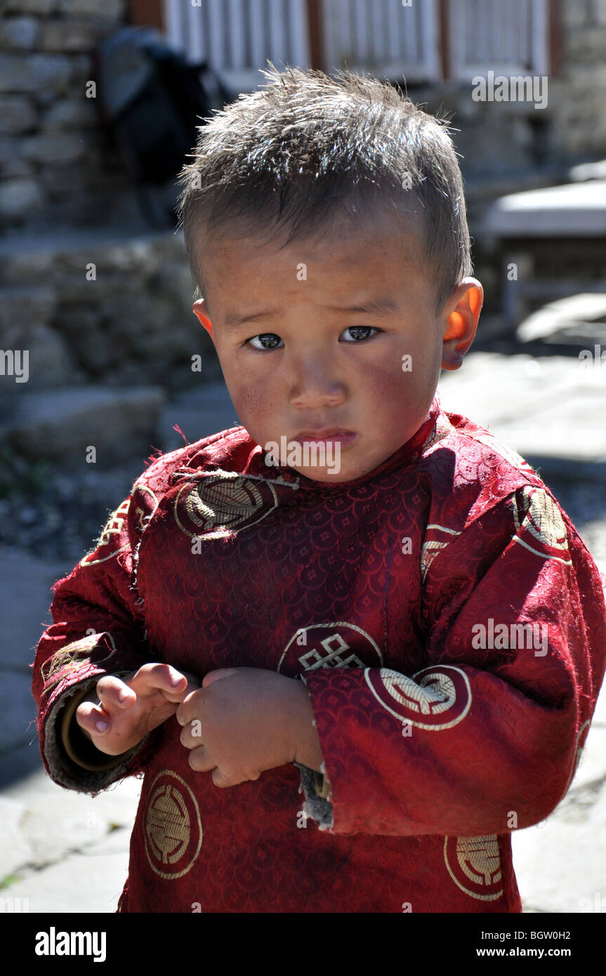 Handsome young Nepalese boy in traditional dress stares into camera Stock Photo