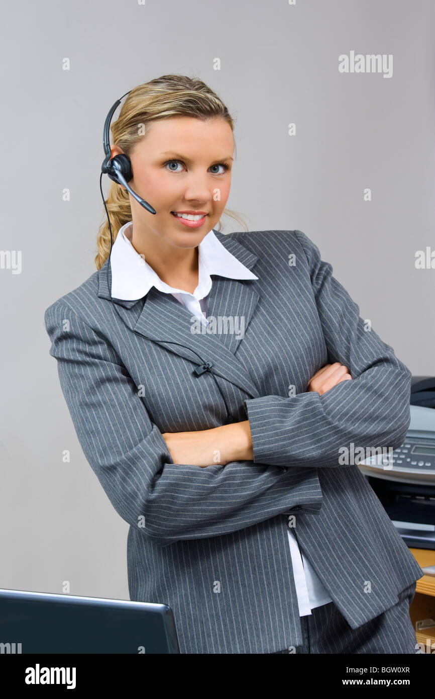 Caucasian businesswoman / secretary in her early 30s talking on a headset Stock Photo