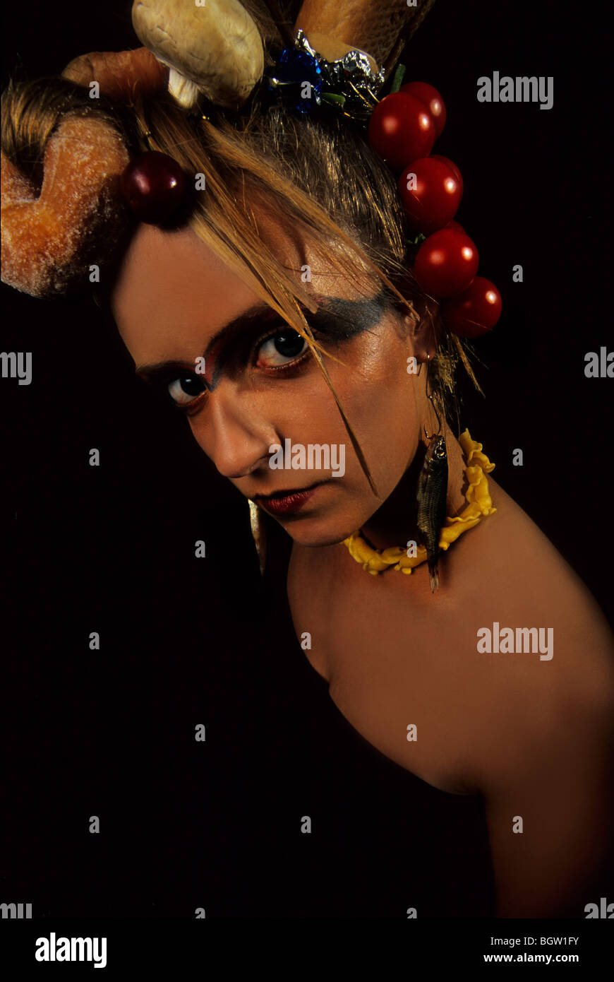 Dramatic image of a girl with food tied into her hair. Stock Photo