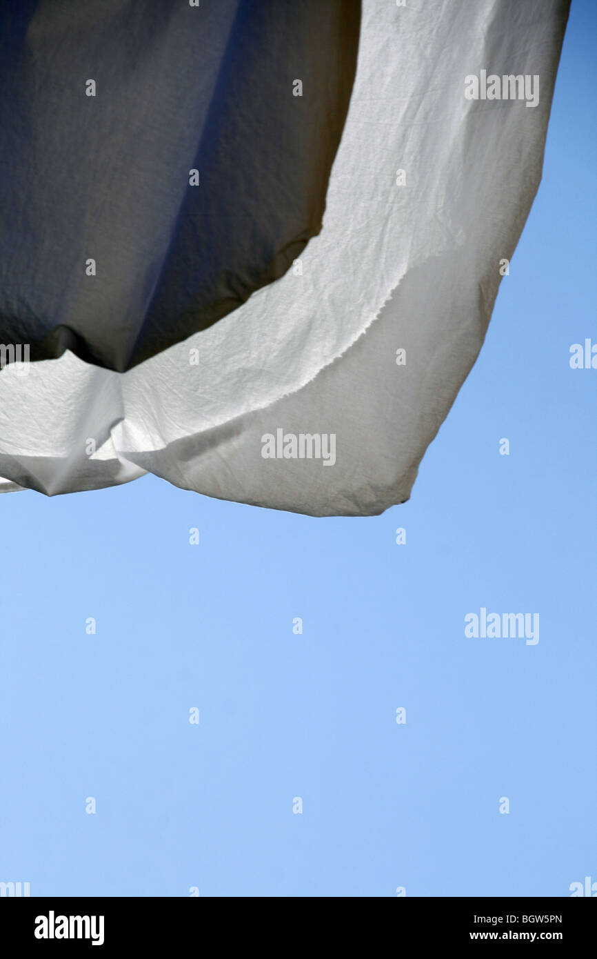 one white bed sheet hanging on washing line in sun Stock Photo Alamy