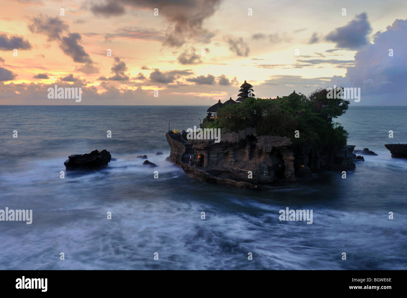 A Hindu temple in an island only when low tide then the worshiper can go there an pray. It is called Pura Tanah Lot Stock Photo