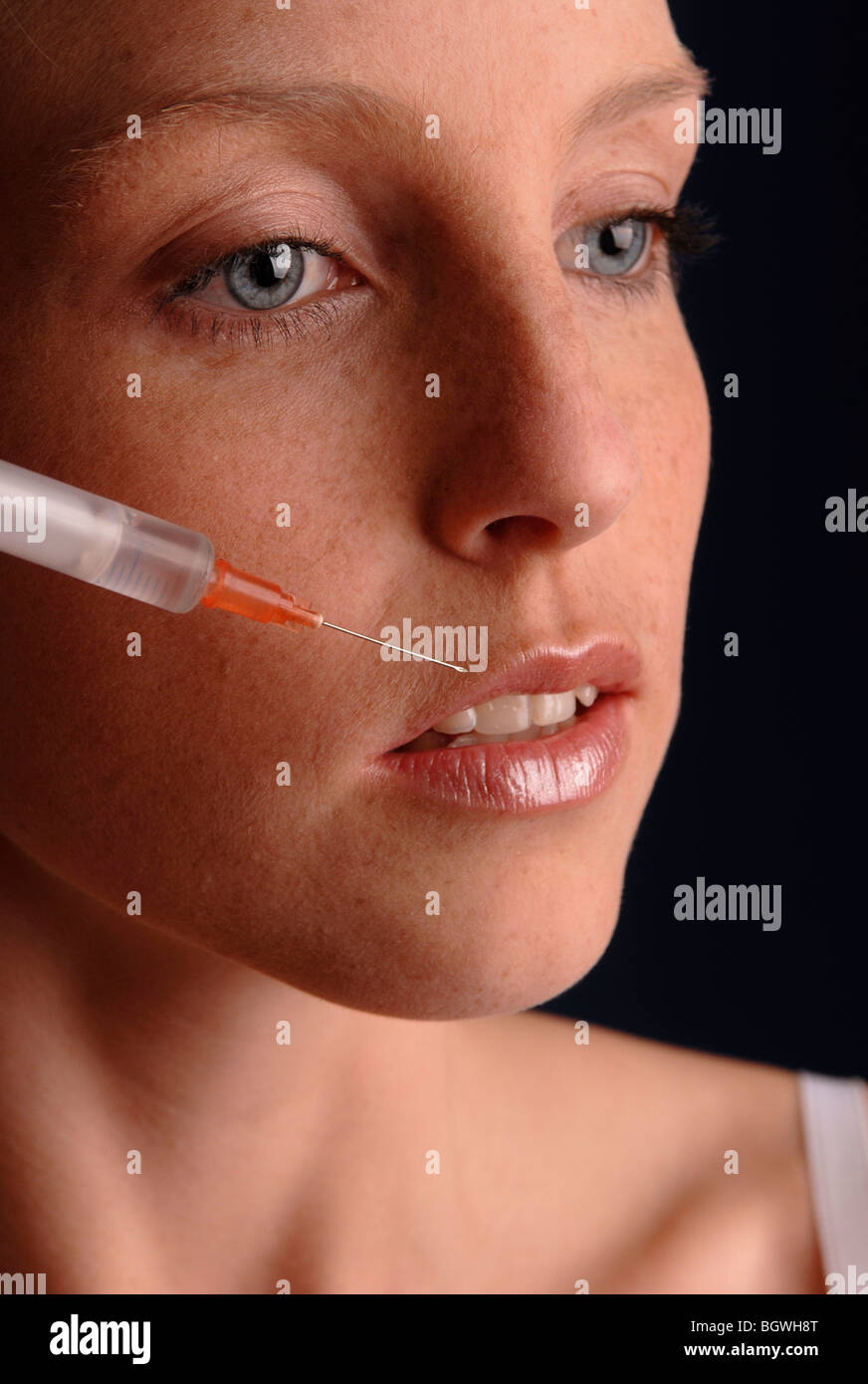 Young woman holding a syringe in her hand Stock Photo